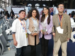 En la imagen Claudia y Stefany recibiendo de regalo una planta de la fundación sumate por la inclusión.